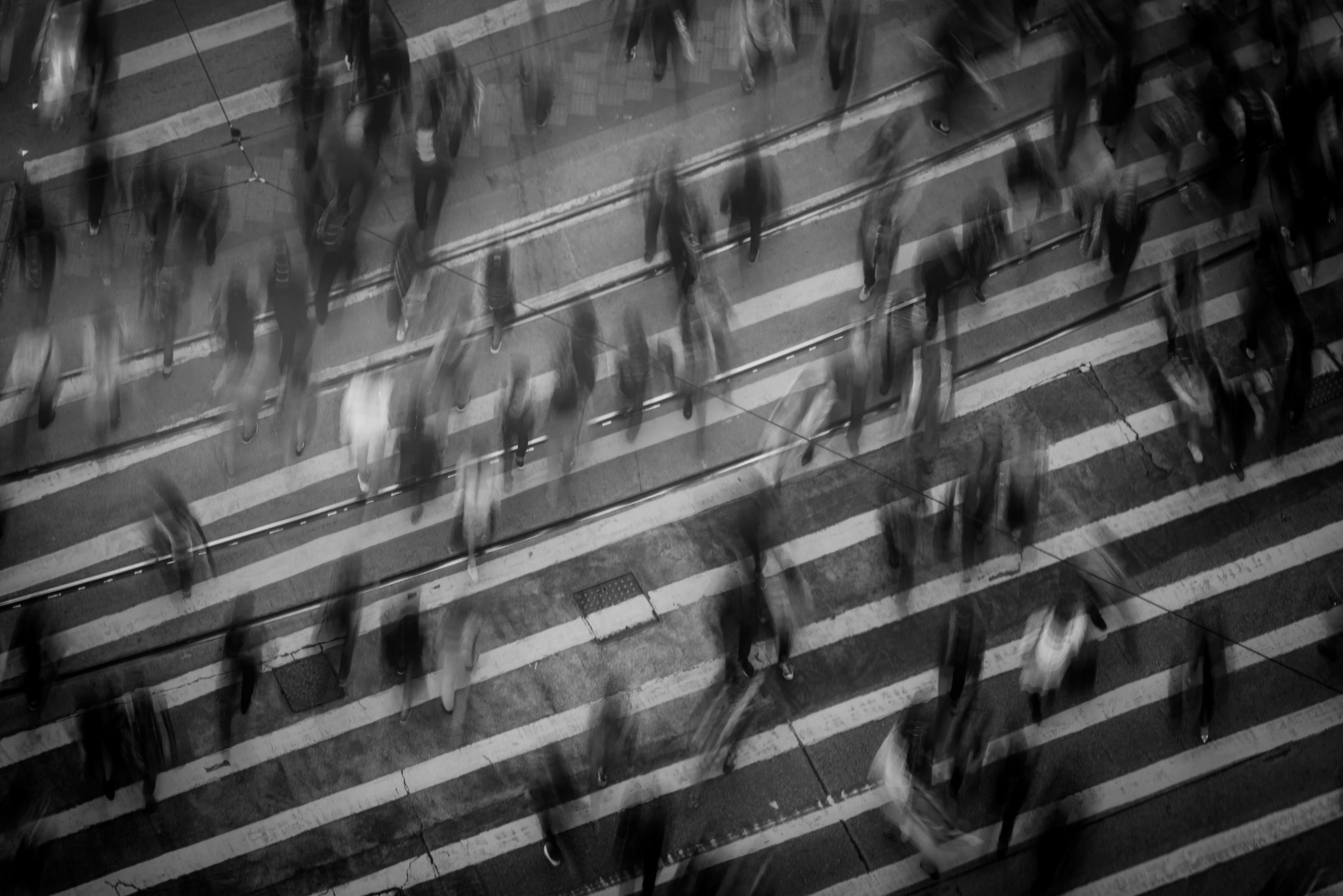 blurred photo of people walking across a street